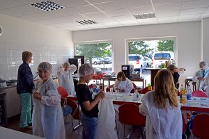 Alle Kinder müssen sich vor der Besichtigung der Küche Schutzkleidung anziehen.