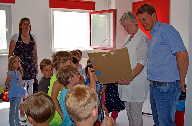 Die Kinder erklären den Mitarbeitern von ALEXMENÜ, was auf dem Bild alles zu sehen ist.
