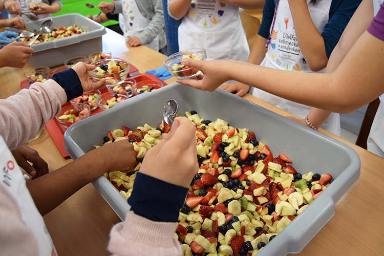 Viele Hände helfen beim Befüllen der kleinen Dessertschalen mit
