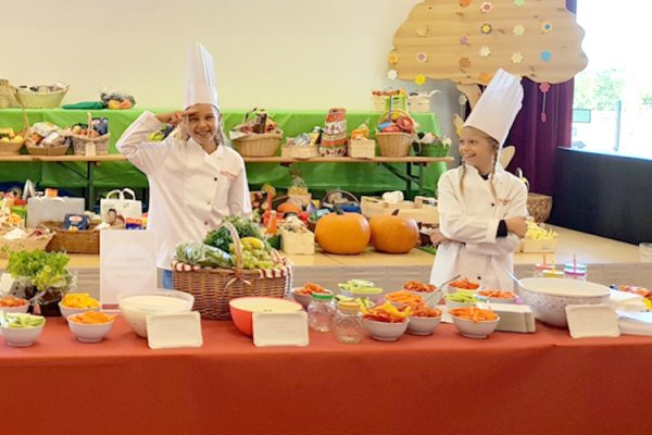 Ausgewählte Kinder präsentieren ihren Mitschülern, was sie in dem Projekt zubereitet haben. ©ALEXMENÜ