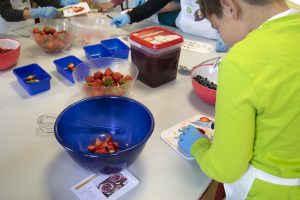 Das Obst wird in kleine Stücke geschnitten, damit es einfacher in das Topping gemischt werden kann. ©ALEXMENÜ