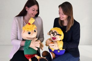 Diätassistentin Juliane Kumstel und Ernährungswissenschaftlerin Lydia Röder (v.l.) führen bei Einrichtungspartnern Ernährungsprojekte mit den Maskottchen Hopsi und Klopsi durch.