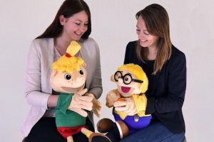 Diätassistentin Juliane Kumstel und Ernährungswissenschaftlerin Lydia Röder (v.l.) führen bei Einrichtungspartnern Ernährungsprojekte mit den Maskottchen Hopsi und Klopsi durch.