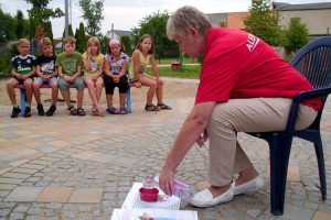 Diätassistentin Marina Bornemann erklärt den Kindern anhand eines überlaufenden Bechers, dass jeder Körper einen Grundumsatz hat. ©Kita Elbstrolche