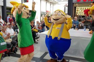 Die Maskottchen tanzen sich vor der großen Parade durch das Einkaufscenter schon mal warm.