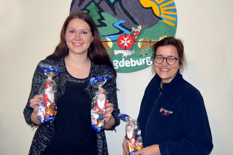 ALEXMENÜ-Kundenbetreuerin Juliane Kumstel (v.l.) übergibt Jugendreferentin Christiane Hess der Malteser Jugend Magdeburg 180 Süßigkeitenbeutel zum Verschenken. ©Maria Kunz/ALEXMENÜ