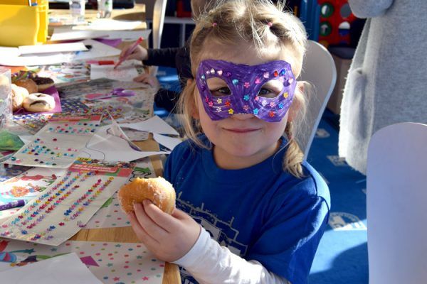 Die KidsClub-Mitglieder freuen sich über die bunten Masken und die leckeren Snacks.